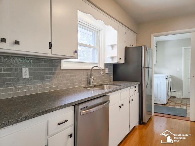 kitchen featuring washer and dryer, dishwasher, a baseboard heating unit, and white cabinets