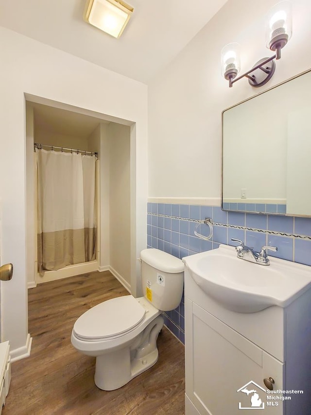 bathroom featuring hardwood / wood-style flooring, vanity, tile walls, and toilet