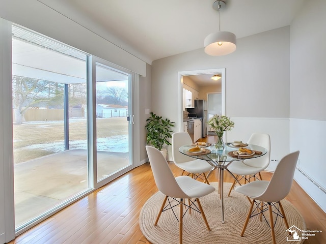 dining space featuring lofted ceiling and light hardwood / wood-style floors