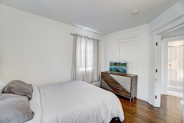 bedroom with dark hardwood / wood-style floors