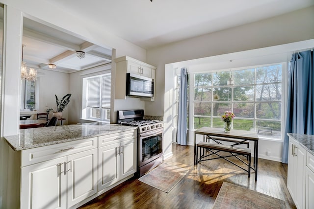 kitchen with appliances with stainless steel finishes, white cabinets, dark hardwood / wood-style flooring, coffered ceiling, and light stone countertops