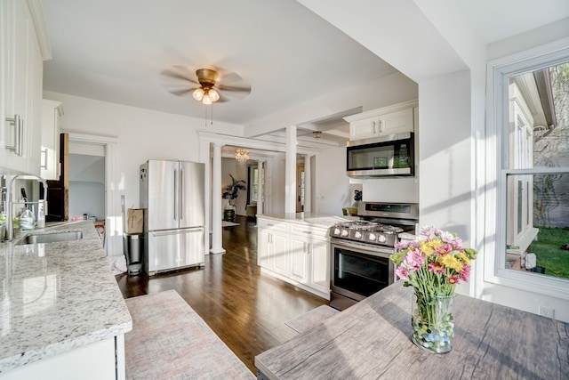 kitchen featuring light stone countertops, stainless steel appliances, dark hardwood / wood-style floors, and white cabinets