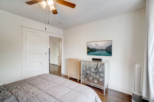 bedroom with ceiling fan, wood-type flooring, and radiator