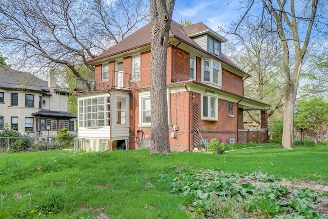 back of property featuring a sunroom and a yard