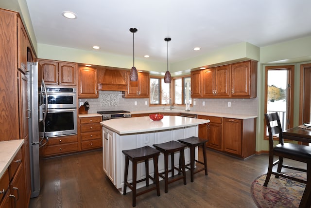 kitchen with brown cabinets, premium range hood, light countertops, and a center island