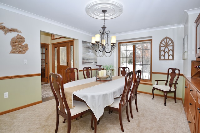 dining space featuring crown molding, baseboards, a notable chandelier, and light colored carpet