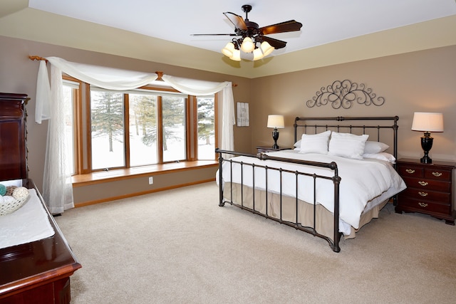 bedroom featuring light carpet, ceiling fan, and baseboards