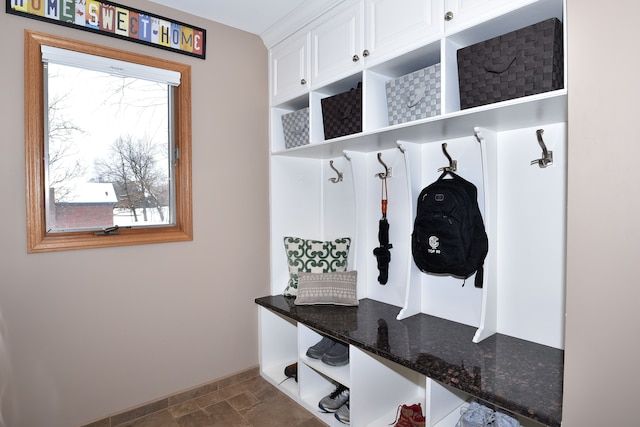 mudroom with stone finish floor, baseboards, and a wealth of natural light