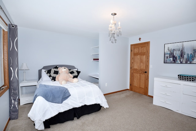 bedroom with baseboards, a chandelier, and carpet flooring