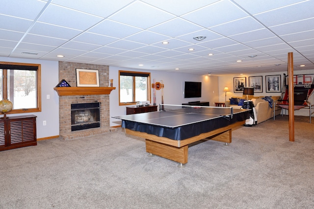 rec room featuring light carpet, a brick fireplace, visible vents, and a healthy amount of sunlight