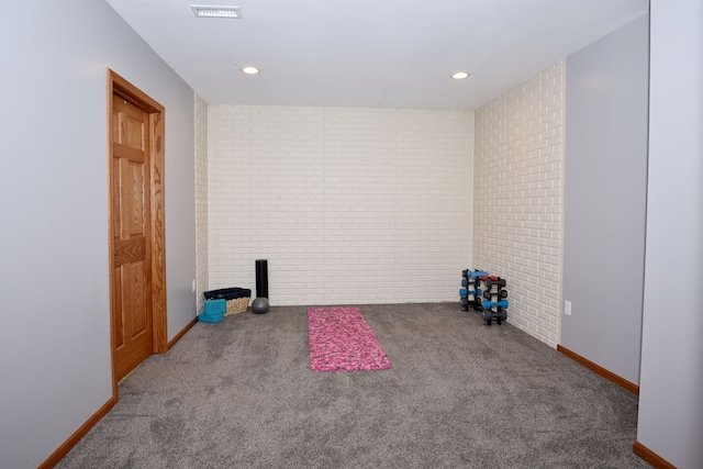 interior space with brick wall, visible vents, and recessed lighting