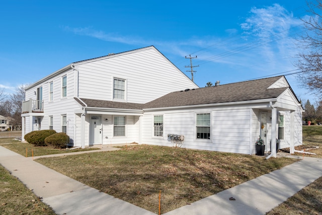 view of front of property with roof with shingles and a front lawn