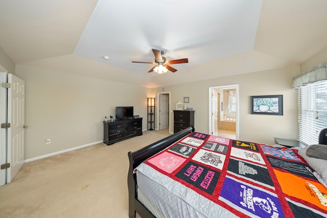 bedroom featuring lofted ceiling, connected bathroom, light colored carpet, and ceiling fan