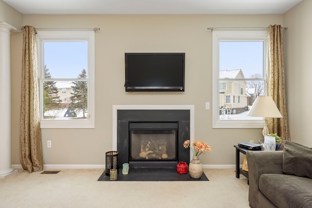 living room with decorative columns and light carpet