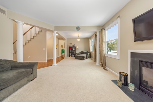 living room featuring ornate columns and carpet