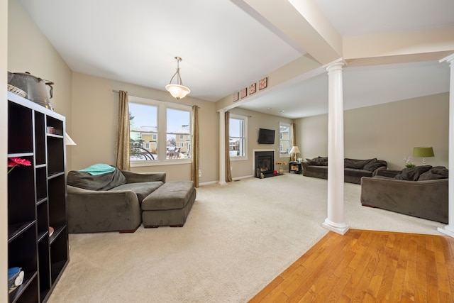 carpeted living room featuring ornate columns