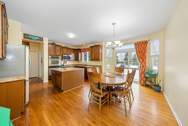 dining room featuring sink, light hardwood / wood-style floors, and a notable chandelier