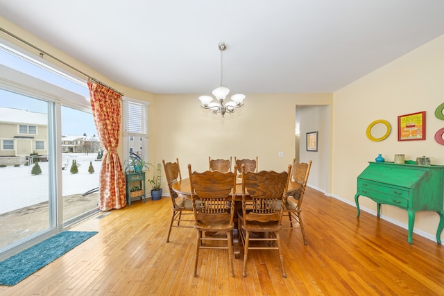 dining space featuring a notable chandelier and light wood-type flooring