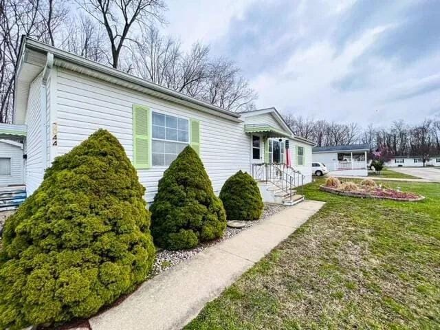 view of side of home with a lawn