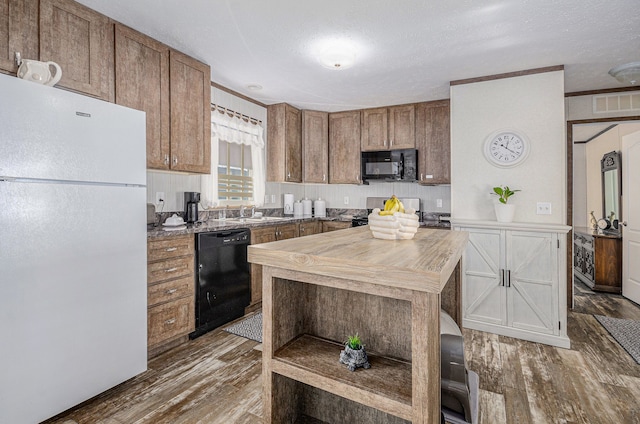 kitchen featuring dark hardwood / wood-style floors, sink, a textured ceiling, and black appliances