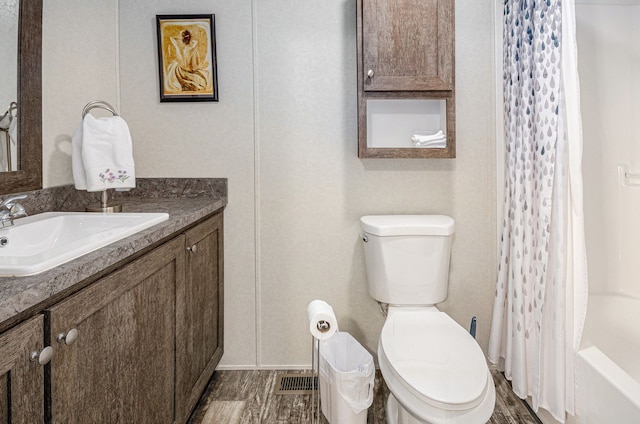 full bathroom featuring vanity, wood-type flooring, and toilet