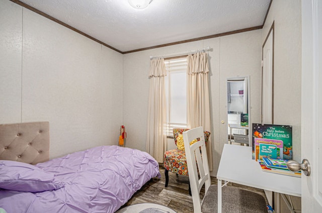 bedroom featuring hardwood / wood-style floors, ornamental molding, and a textured ceiling