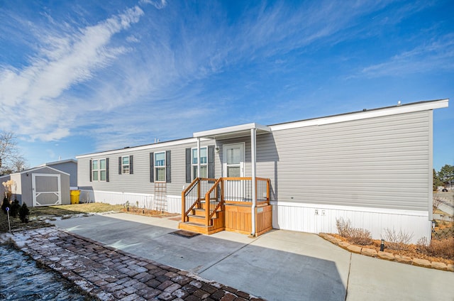 view of front of property with a storage shed and a patio