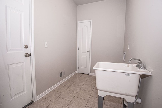 bathroom featuring a sink, baseboards, tile patterned flooring, and visible vents