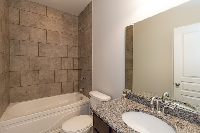 full bathroom with tiled shower / bath, vanity, and toilet