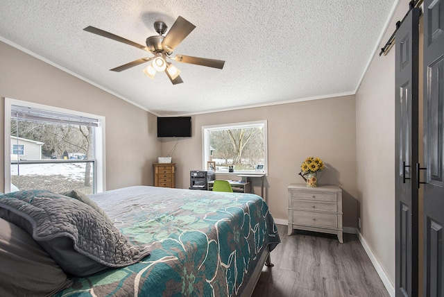 bedroom with lofted ceiling, wood-type flooring, a textured ceiling, ornamental molding, and ceiling fan