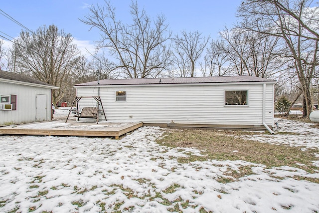 snow covered rear of property with a deck