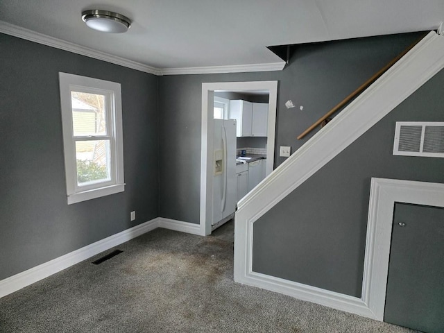 carpeted foyer entrance with ornamental molding