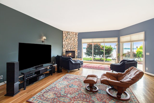 living room with a healthy amount of sunlight, a fireplace, and light wood-type flooring