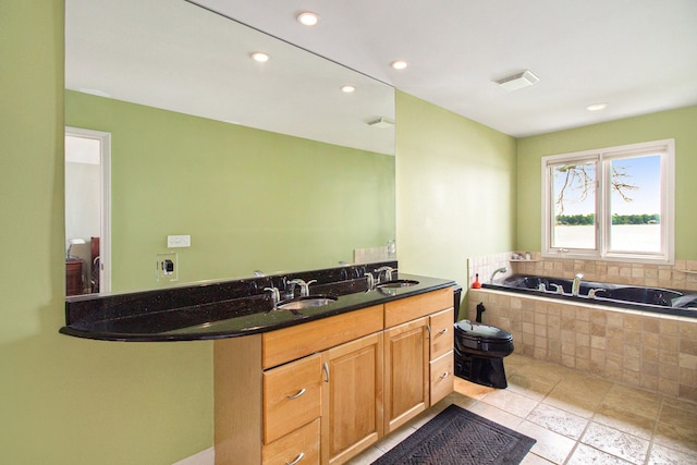 bathroom featuring vanity, toilet, and tiled tub