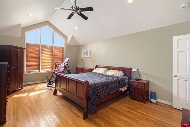 bedroom with ceiling fan, vaulted ceiling, light hardwood / wood-style flooring, and an AC wall unit