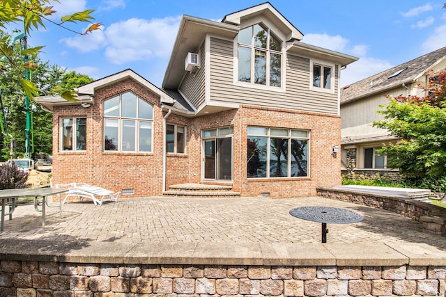 back of house featuring a patio area and a wall unit AC