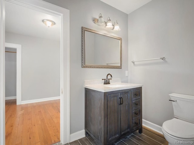 bathroom with vanity, wood-type flooring, and toilet