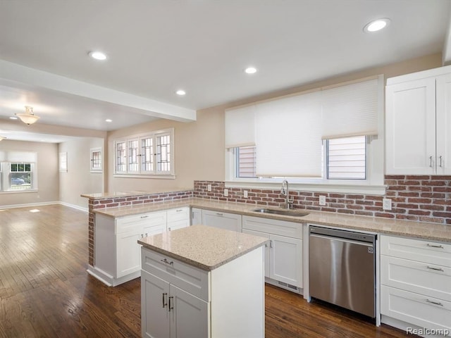 kitchen featuring sink, a center island, light stone counters, white cabinets, and stainless steel dishwasher