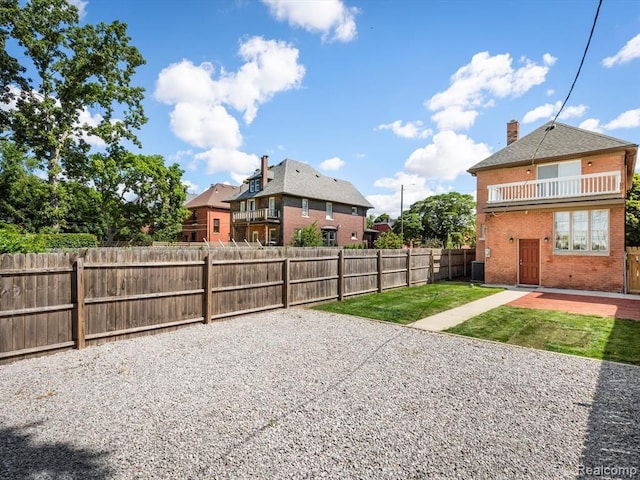 view of yard featuring central AC, a patio, and a balcony