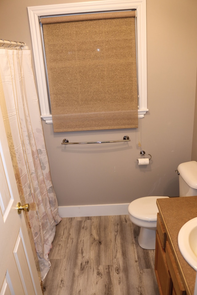 bathroom with wood-type flooring, toilet, and vanity