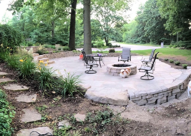 surrounding community with a fire pit and a patio