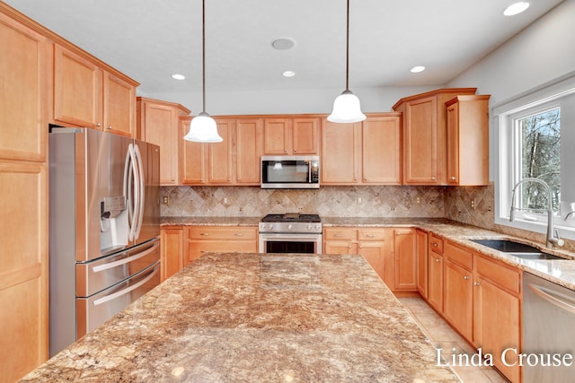 kitchen with light stone counters, stainless steel appliances, a sink, light brown cabinetry, and tasteful backsplash