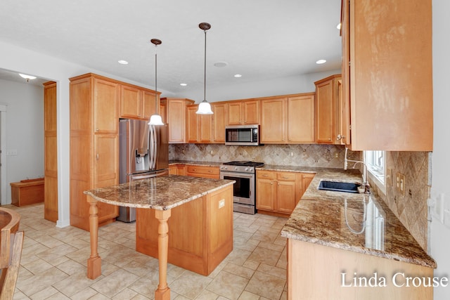 kitchen with a center island, appliances with stainless steel finishes, a sink, light stone countertops, and a kitchen bar