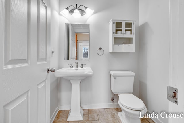 bathroom with tile patterned flooring, toilet, and baseboards