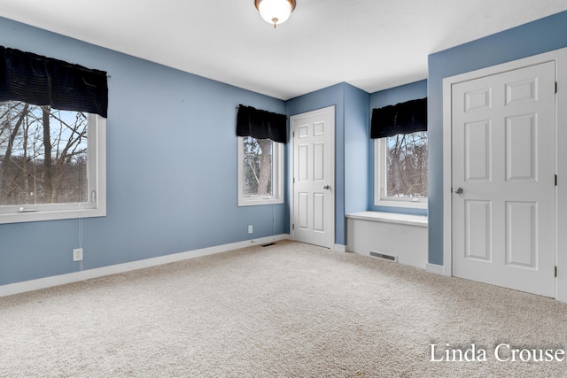 unfurnished bedroom with baseboards, visible vents, and carpet flooring