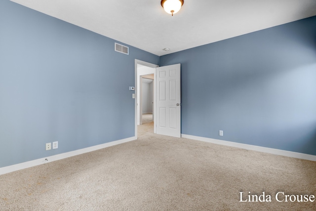 unfurnished room featuring baseboards, visible vents, and carpet flooring