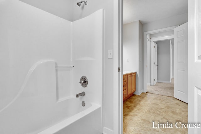 full bathroom with shower / bath combination, tile patterned flooring, vanity, and baseboards