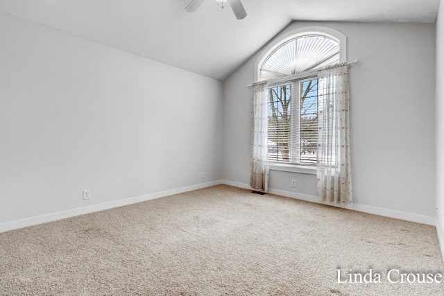 carpeted spare room featuring lofted ceiling, ceiling fan, and baseboards