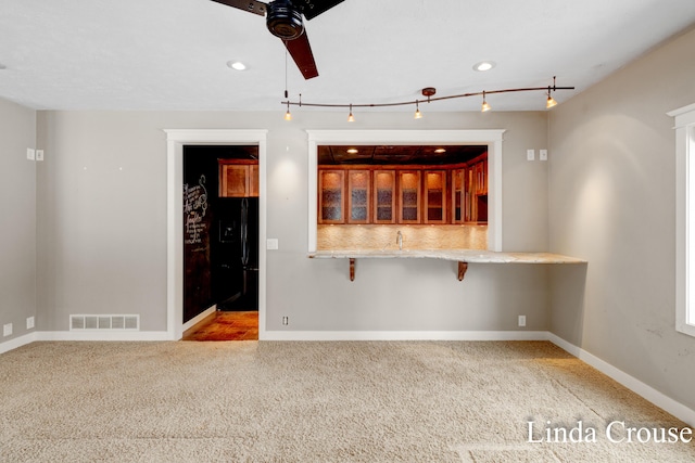 unfurnished room featuring ceiling fan, carpet flooring, visible vents, and baseboards