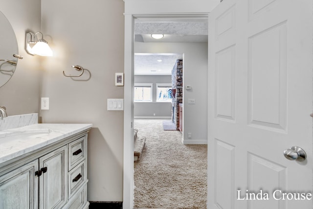 bathroom featuring a textured ceiling, vanity, and baseboards